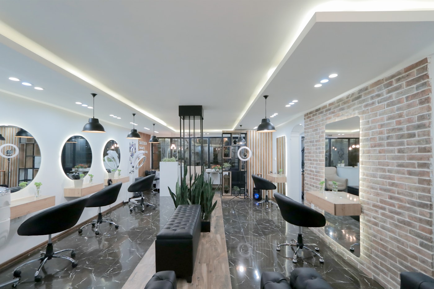 Inside Alder and Ash: round mirrors, brick wall, and styling chairs